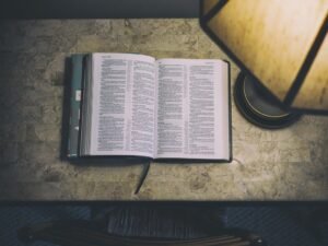 An open Bible on a desk beside a lamp – setting aside three days of fasting to seek God through His Word and prayer