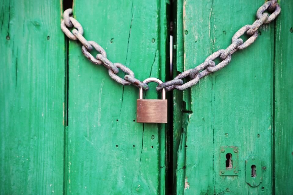 Chain and padlock on a green wooden door – old covenants and the freedom Christ brings