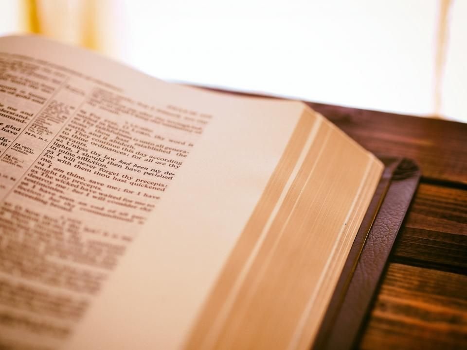 Open book on a wooden table in soft light – reading Bible verses against spiritual attacks in dreams
