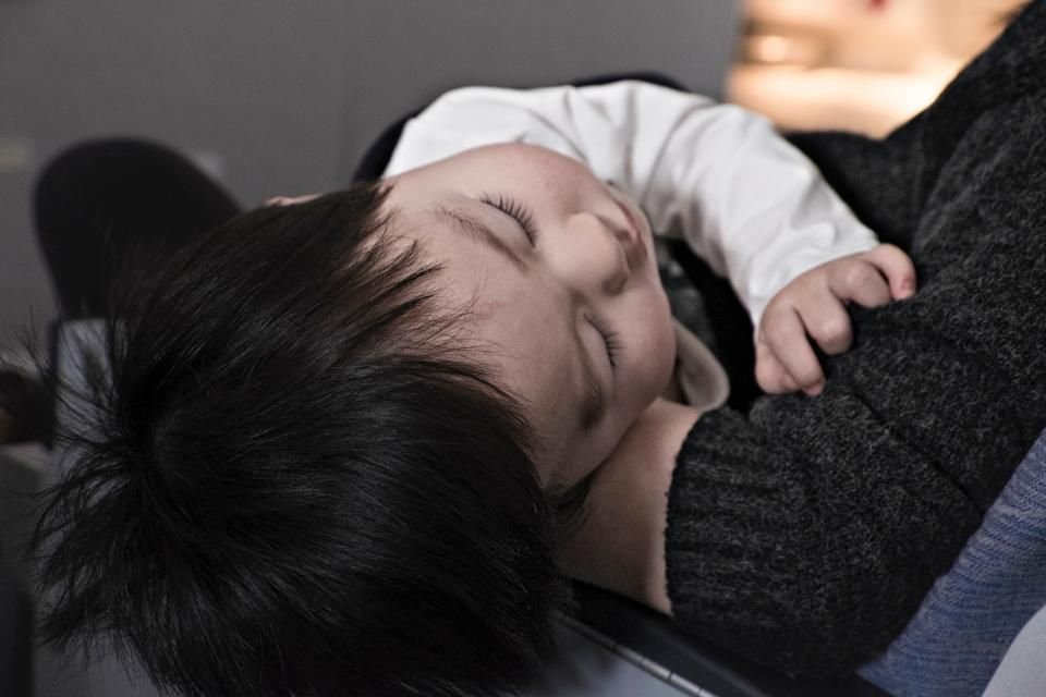 Young child sleeping peacefully in a parent’s arms after a calm bedtime routine and prayer