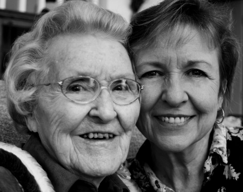 An elderly mother and her grown daughter smiling cheek to cheek – “Thou shalt come to thy grave in a full age” (Job 5:26)