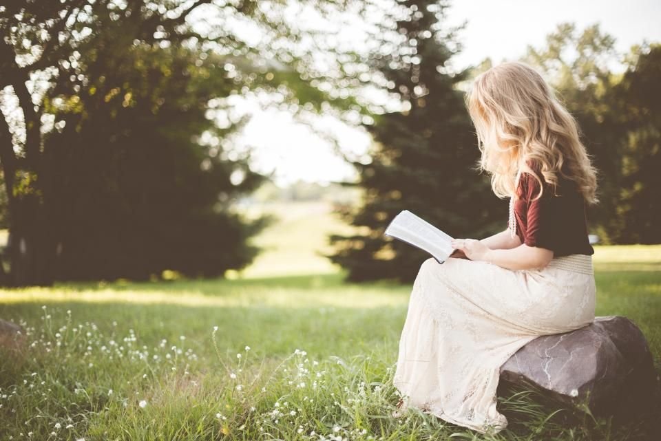 Woman sitting outdoors reading her Bible – testing a dream by the Word to know if it is from God