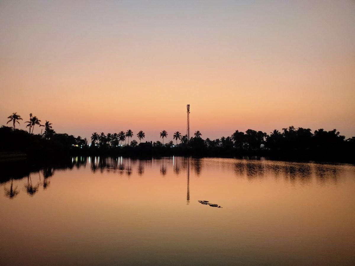 Tranquil lake at sunrise with palm trees reflected in calm water – a peaceful setting for marine spirit deliverance prayer