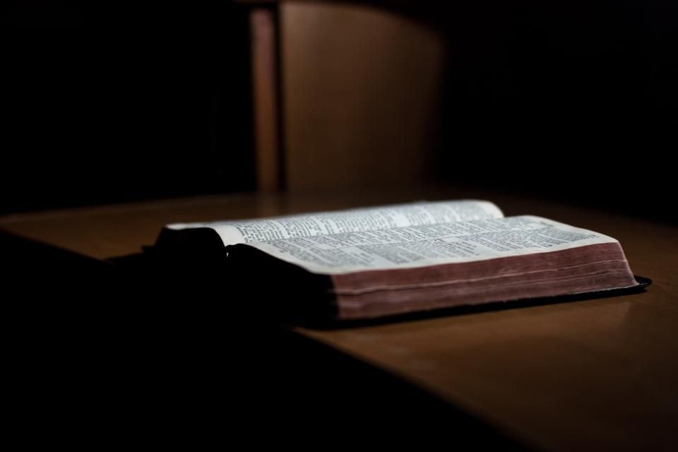 Open Bible on a wooden table in soft evening light – praying marine spirit prayer points from Scripture