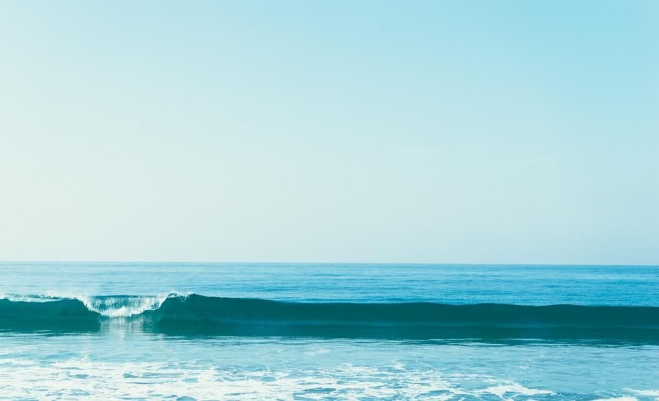 Calm turquoise ocean wave under a clear sky – seeking marine spirit signs with peace, not fear