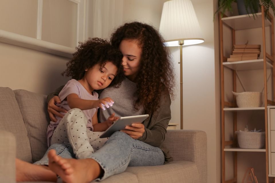 A mother sitting with her young daughter on the sofa, sharing a quiet moment together – praying for my children