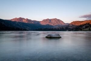 A calm, still mountain lake at dawn – a picture of the peace of mind God gives to those who trust Him