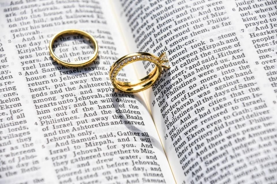 Two wedding rings resting on the open pages of a Bible – seeking signs of spiritual husband in a relationship with Scripture