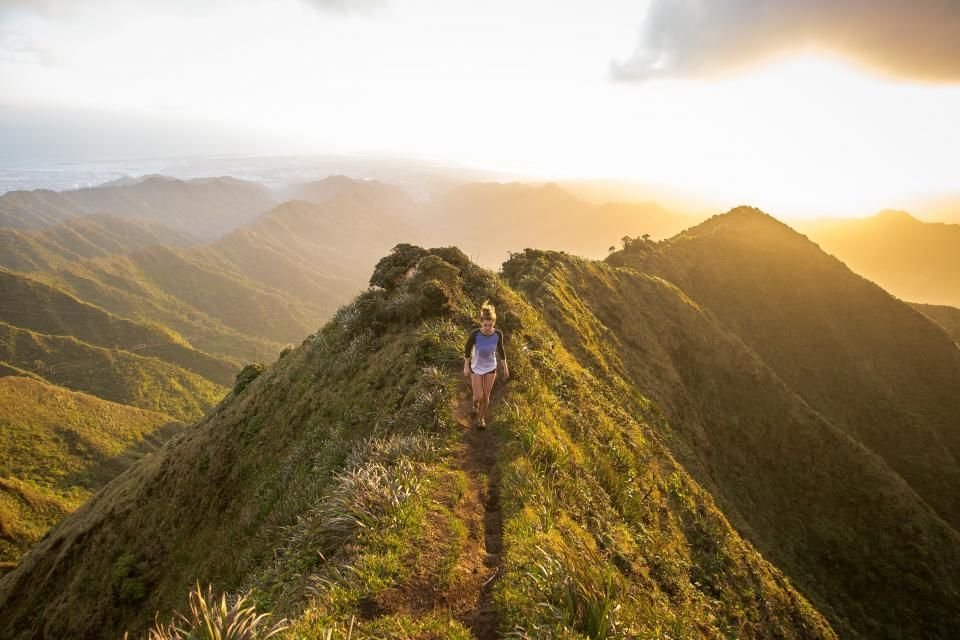 A person walking a green mountain path at sunrise – a new journey of acceptance in Christ