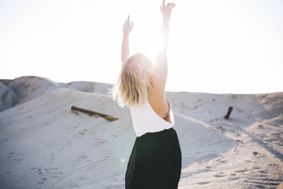 A woman lifting her arms in the open air – walking free from the spirit of rejection