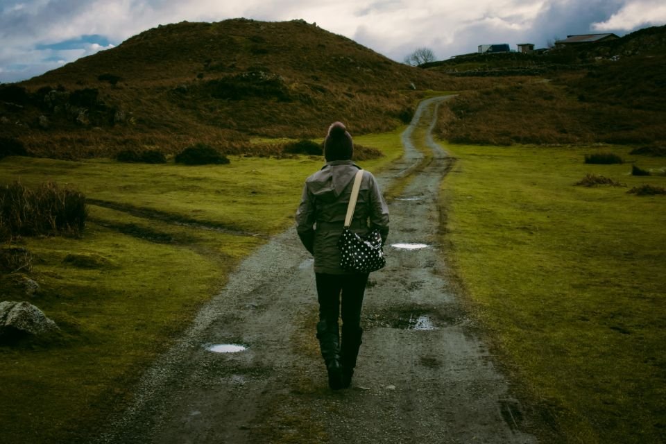 Woman walking forward on a green country path – moving on in freedom after breaking soul ties